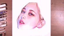 a drawing of a woman 's face is surrounded by pencils