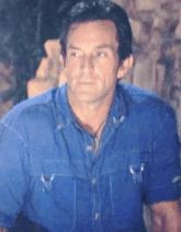 a man in a blue shirt is looking at something