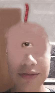 a close up of a man 's face with a red worm sticking out of his head