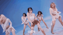 a group of women are dancing in front of a blue background with choom written on it
