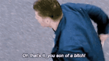 a man in a blue shirt is talking to another man .