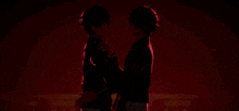 a couple of anime characters are standing next to each other in front of a red background .