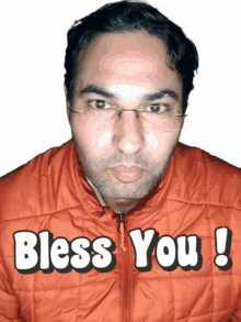 a man wearing glasses and an orange jacket with the words bless you written on it