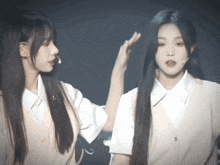 two girls are standing next to each other and one of them has a microphone in her ear