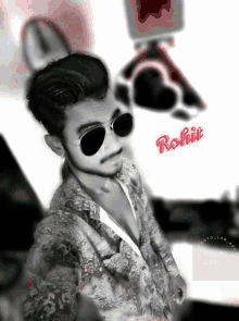 a black and white photo of a young man with the name rohit on the bottom