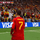 a soccer player wearing a red jersey with the number 7 on it