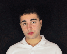a young man wearing a white shirt with a black background