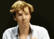 a man with blonde hair is making a funny face .