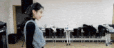 a woman is standing in a room with chairs and tables