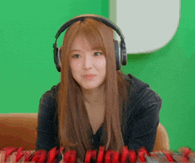 a woman wearing headphones is sitting in front of a green screen that says " flashlight "