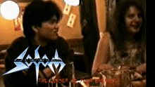 a man and a woman are sitting at a table with the leader of your enemies in red letters