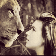 a woman is looking at a lion 's nose in a black and white photo