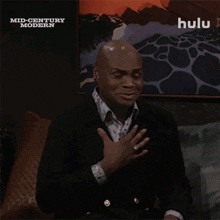 a man is pointing up in front of a hulu ad