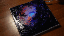 a painting is being painted with a fork on a wooden table