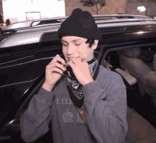 a man wearing a lyle sweatshirt and a beanie