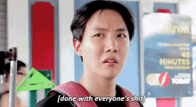 a young man is standing in front of a sign that says `` done with everyone 's shit . ''