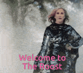 a woman in a sequined dress is standing in front of a sign that says " welcome to the roost "