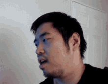 a close up of a man 's face with a white door in the background