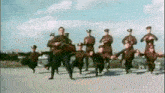 a group of soldiers are dancing in a line on the ground .