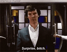 a man in a suit says surprise bitch in front of a building