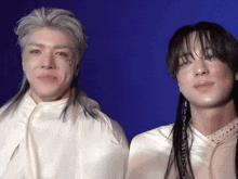 a man with gray hair is standing next to a woman with black hair