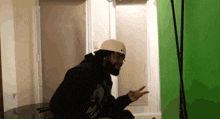 a man with a beard wearing a white helmet and a black hoodie