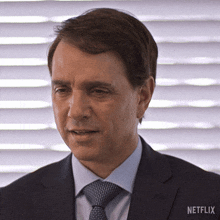 a man in a suit and tie with a netflix logo on the bottom