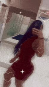 a woman in a red dress is taking a selfie in a bathroom mirror