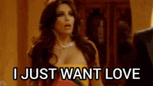 a woman in a yellow dress is saying `` i just want love '' while standing next to a man in a suit .