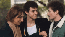 a man in a green jacket is shaking hands with two women