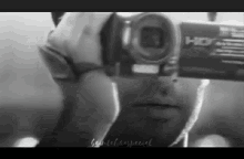 a black and white photo of a man taking a picture of himself with a camera .