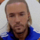 a man with long hair is wearing a blue shirt