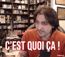 a man wearing an orange shirt with the words c'est quoi ca written on it