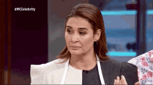 a woman wearing an apron and earrings is on a television show called mccelebrity .