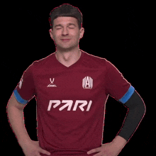 a man wearing a red shirt with pari on the front