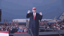 a man wearing a maga hat stands on a stage