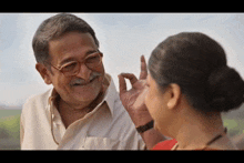 an elderly man with glasses and a mustache is talking to a young woman .