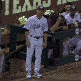 a man in a striped aggies jersey stands on the field