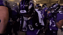 a group of ravens football players are standing in a locker room