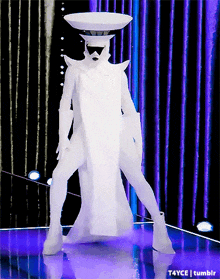 a person in a white costume is standing on a stage with purple curtains in the background