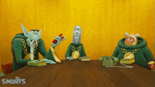 three smurfs are sitting at a table with phones and books