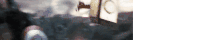 a blurred image of a clock hanging from a pole in the air .