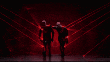 two people are dancing in front of a red light
