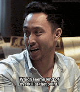 a man in a plaid shirt is smiling and says which seems kind of overkill at that point
