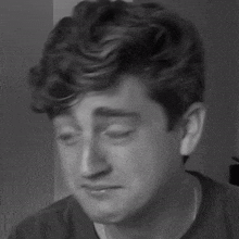a black and white photo of a man 's face with his eyes closed