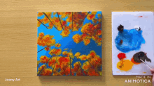 a painting of autumn leaves is being painted on a canvas by joony art