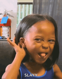 a little girl is making a funny face and the word slayy is on the bottom right