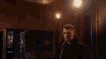 a man singing into a microphone in a dark room