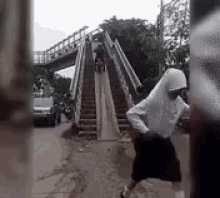 a person is walking down a set of stairs in the rain .