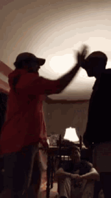 two men are giving each other a high five in a room